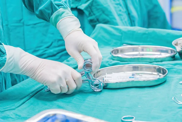Gloved hands handling surgical instruments