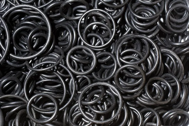 A pile of black rubber O-rings and seals